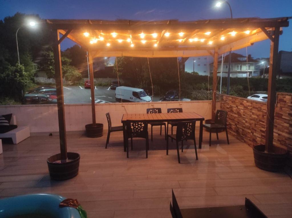 un patio avec une table et des chaises sous un pavillon éclairé dans l'établissement La Terraza de Castelao, à O Grove