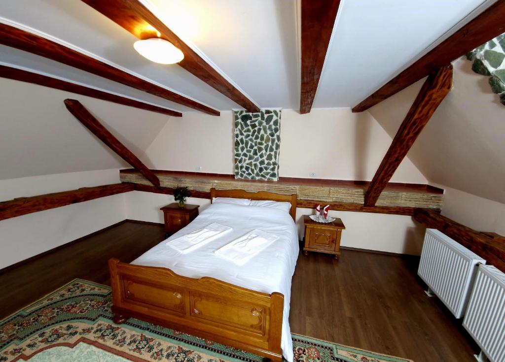 sypialnia z dużym łóżkiem na poddaszu w obiekcie Mehadica House w mieście Mehadica