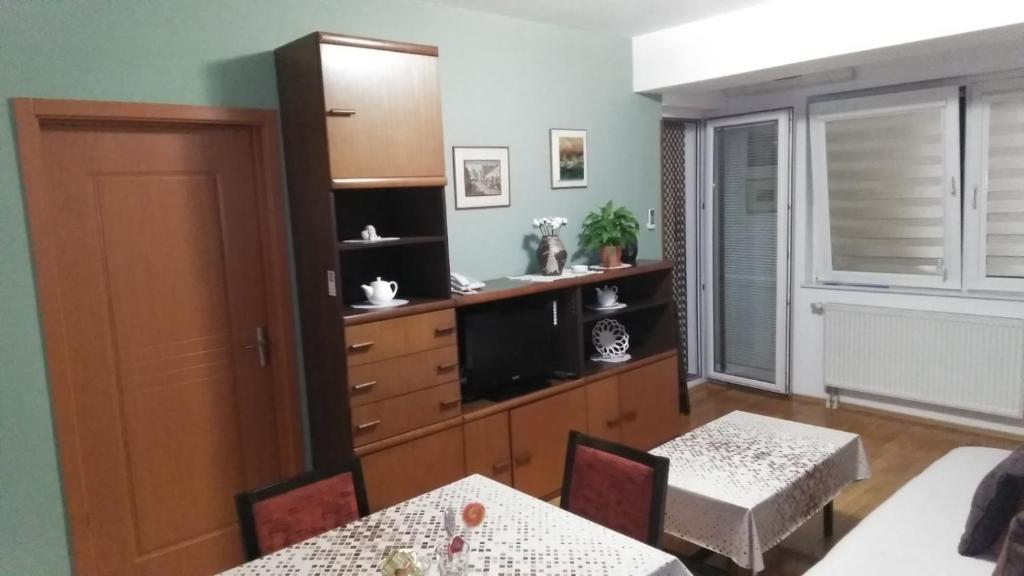 un salon avec deux tables et une cuisine dans l'établissement apartment24, à Skopje
