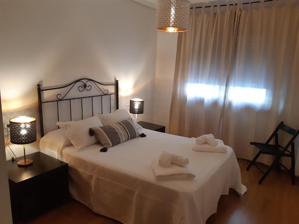 - une chambre avec un lit et 2 serviettes dans l'établissement Apartamento Reguiño al mar, à A Guarda