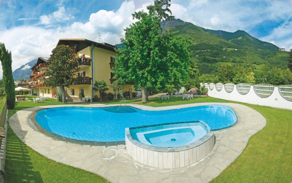 a swimming pool in a yard next to a house at Hotel Elisabeth in Merano