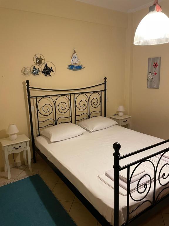 una camera da letto con letto nero, lenzuola e cuscini bianchi di Aurora Apartment ad Áfitos