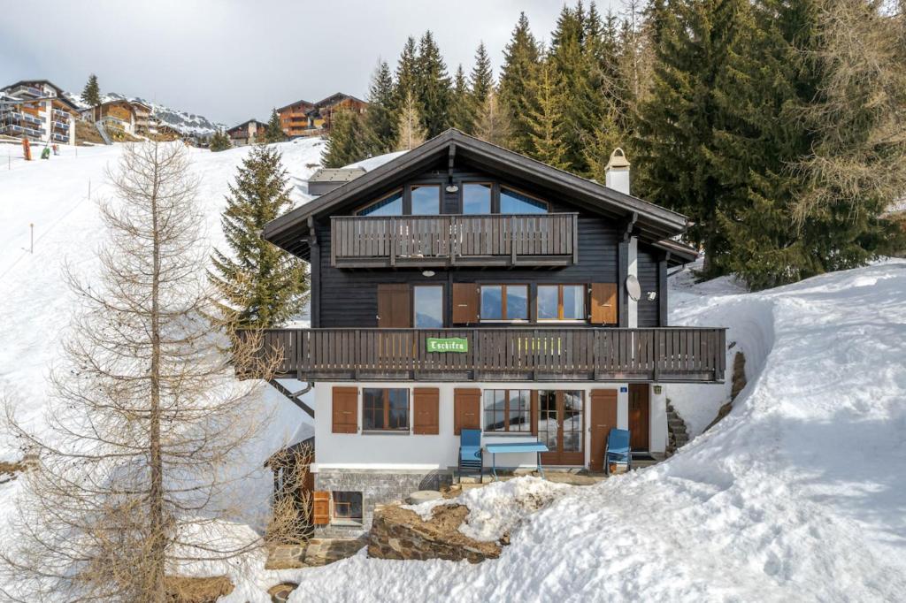 een houten huis in de sneeuw met bomen bij Tschiffra OG in Bettmeralp