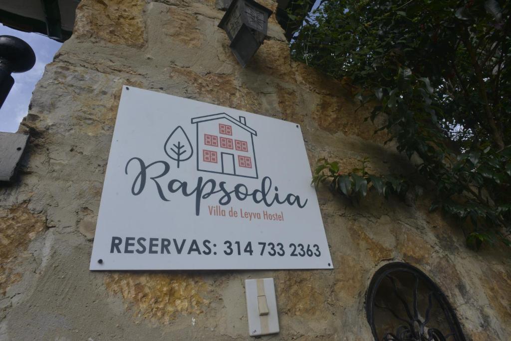 ein Schild an der Seite eines Gebäudes in der Unterkunft RAPSoDIA HOSTEL in Villa de Leyva