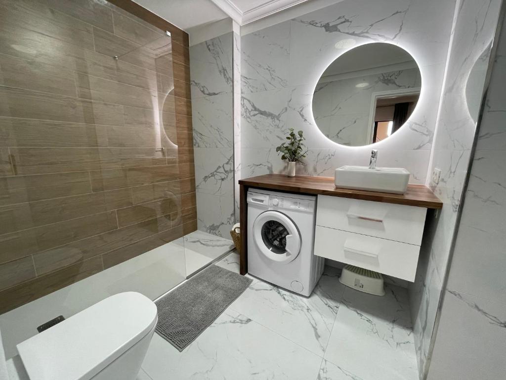 bagno con lavatrice e specchio di Villa Moleiro - Golf del Sur a San Miguel de Abona