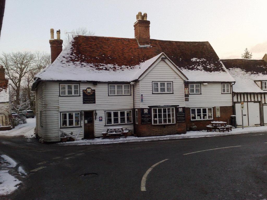 a inn with snow on the roof on a street at The Chequers Inn in Smarden