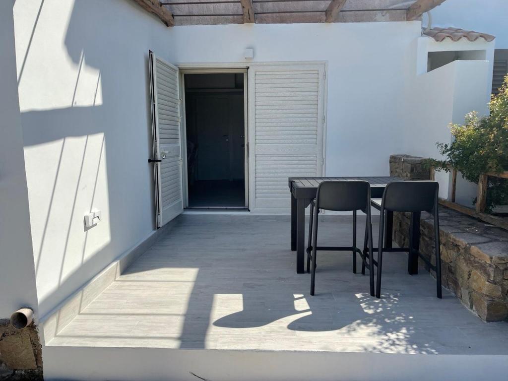 patio ze stołem i krzesłami przed domem w obiekcie Villa GEGI w mieście Budoni