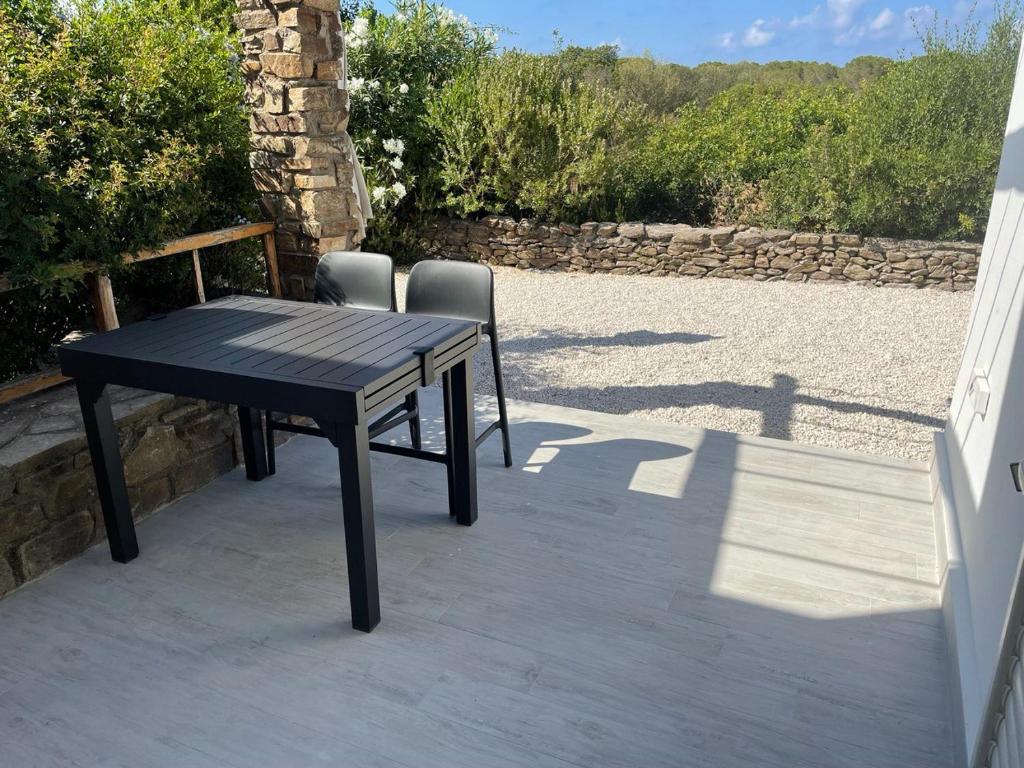 czarny stół i 2 krzesła na patio w obiekcie Villa GEGI w mieście Budoni