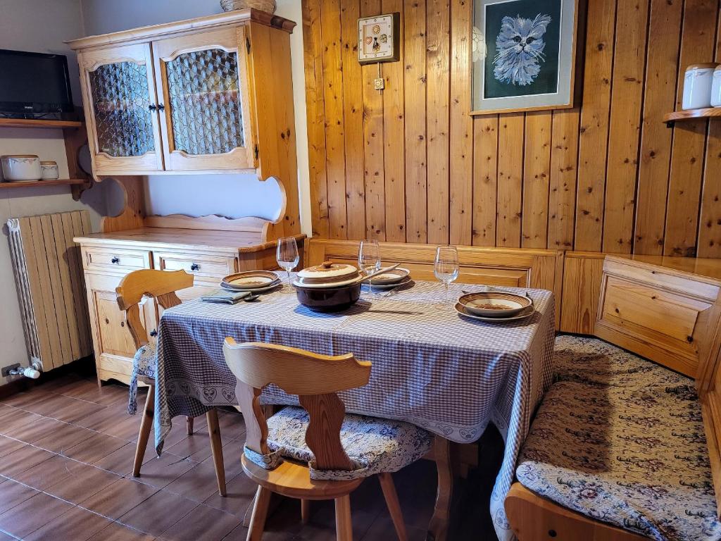 Un comedor con una mesa con platos y copas de vino. en Peace and Lake Mountain Lake Iseo Hospitality, en Bossico