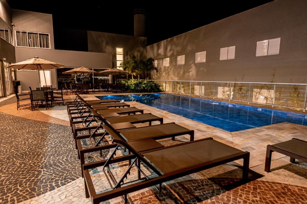 Gaben Hotel في جاو: صف طاولات وكراسي بجانب مسبح