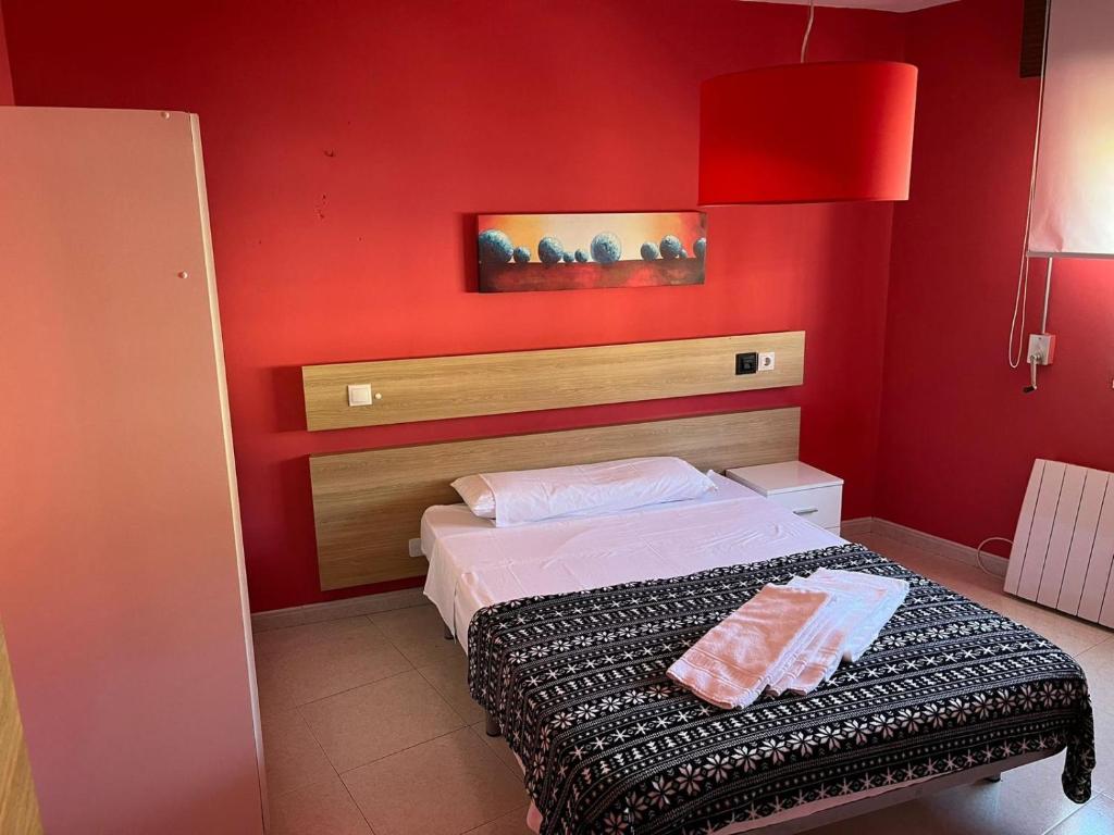 czerwona sypialnia z łóżkiem i czerwoną ścianą w obiekcie Residencia Vista Alegre w Santiago de Compostela