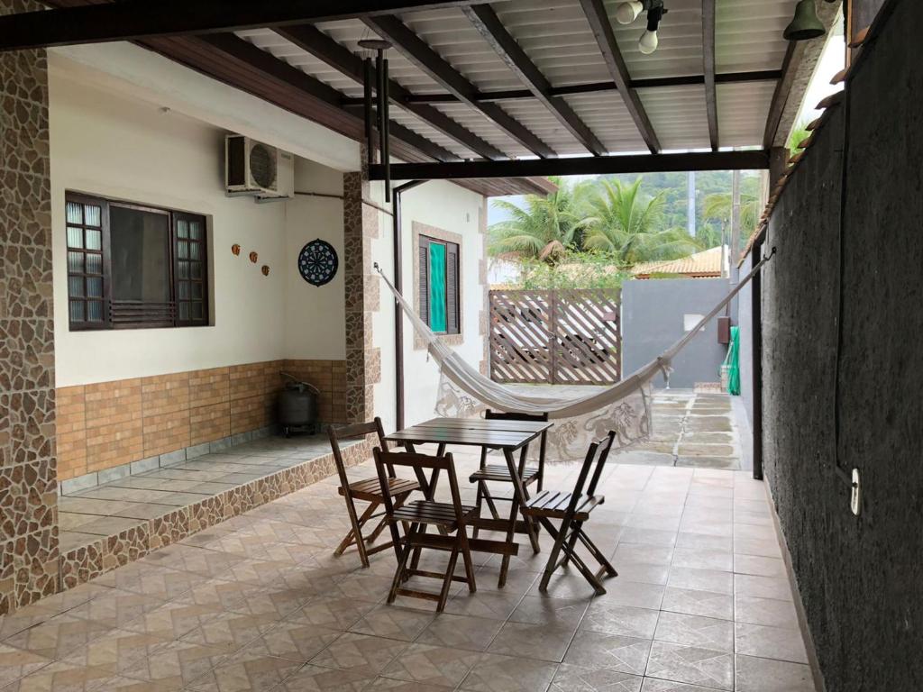 a patio with a table and chairs in a house at Chalés Alencar in Caraguatatuba