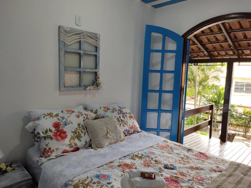 a bedroom with a bed with a blue and white bedspread at Mar de Maria Pousada in Búzios