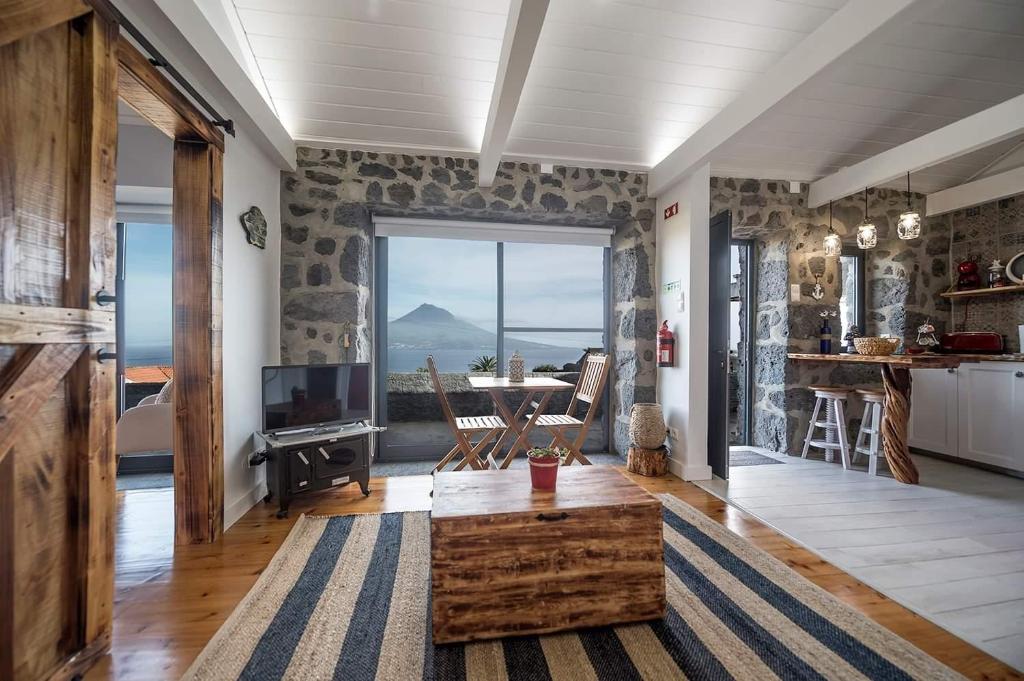 a living room with a table and a view of the ocean at Casa Mar do Triângulo in Horta