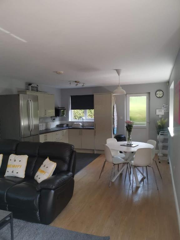 a living room with a black couch and a white table at Green Street Retreat in York