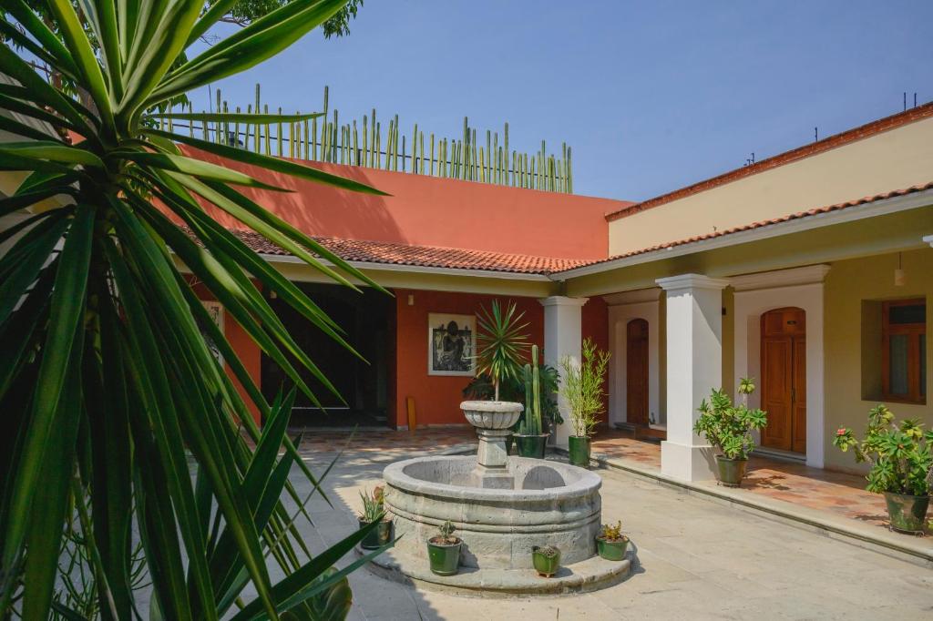 a courtyard with a fountain in front of a house at XTILU Hotel - Adults only - in Oaxaca City