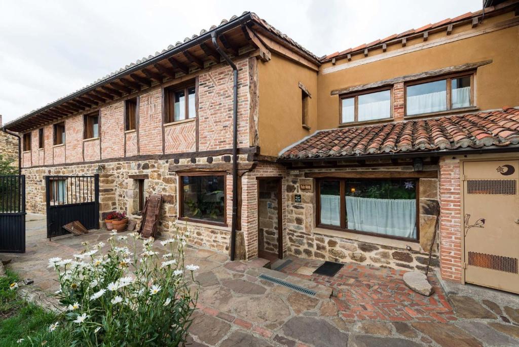 an old stone house with a courtyard at Hotel Rural Piedra Abierta in San Martín de Perapertú