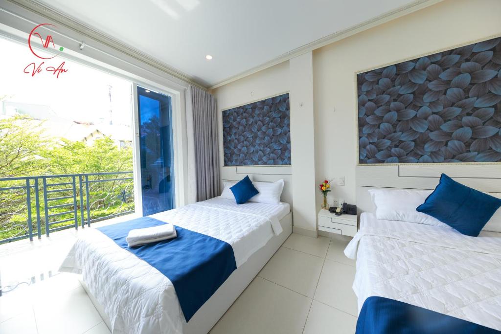 Duas camas num quarto com varanda em Vi An Hotel em Ho Chi Minh