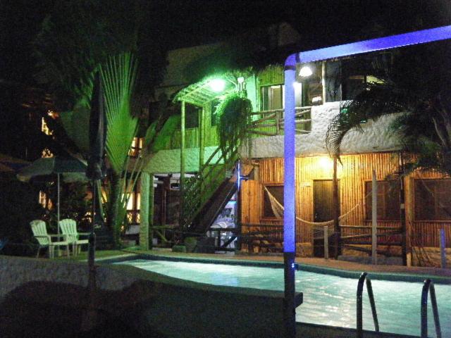 a house with a swimming pool at night at CABAÑAS ECOLOGICAS STEPHANIE JIRETH in Tonsupa