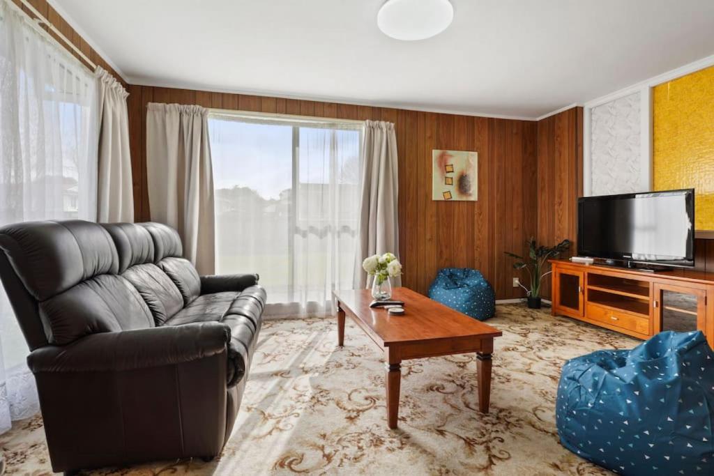 un soggiorno con divano e TV di Family 3BR Home with Netflix and Fully Fenced Yard ad Auckland