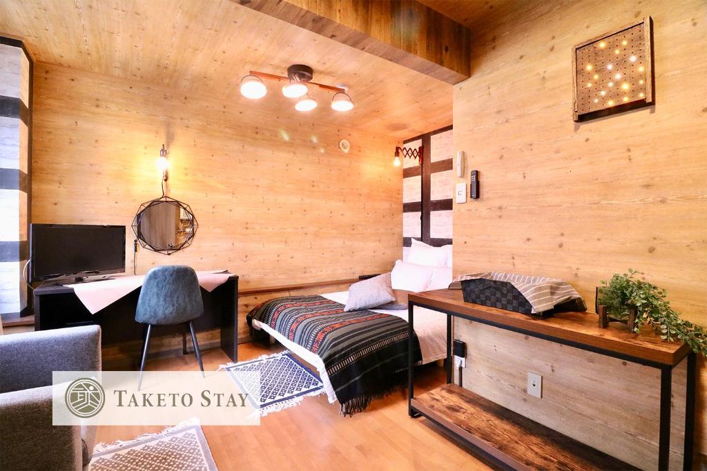 een woonkamer met houten wanden en een bureau bij Culture24 in Sapporo