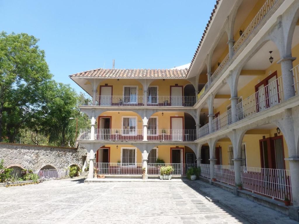 a large yellow building with a courtyard at Hotel del Rio in Orizaba