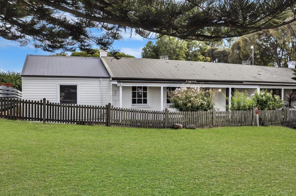 a white house with a fence in front of it at Lyons in Port Fairy