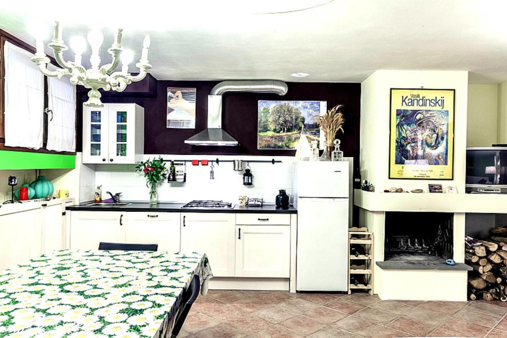 a kitchen with white cabinets and a stove top oven at Tavernetta con camino in collina in Pianoro