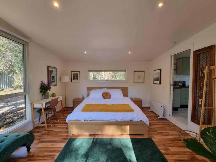 a bedroom with a large bed and a large window at Bellshala bungalow in Bellbrae