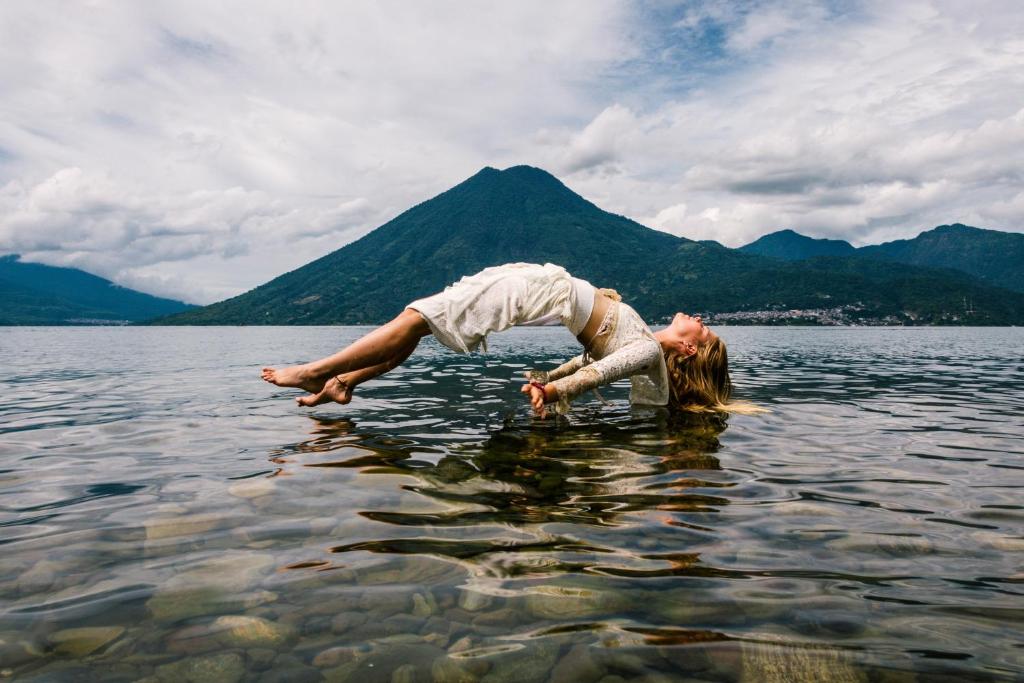 uma mulher mergulhando em um corpo de água em Del Lago Hotel em San Marcos La Laguna