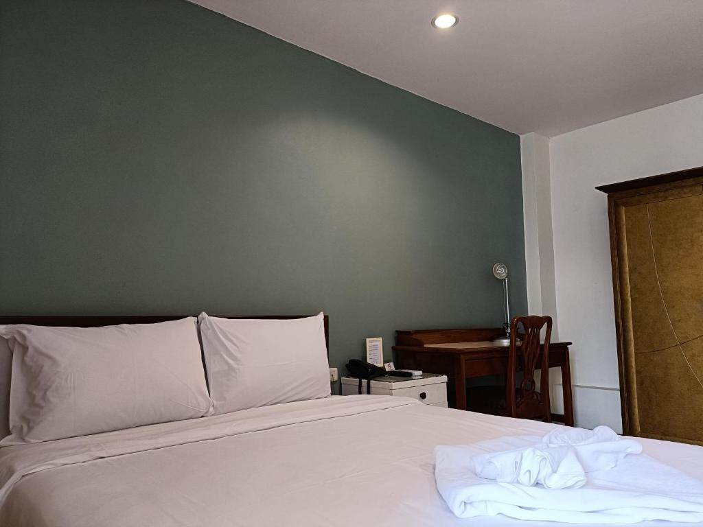 A double bedroom centered on a green accent wall with a compact writing desk.