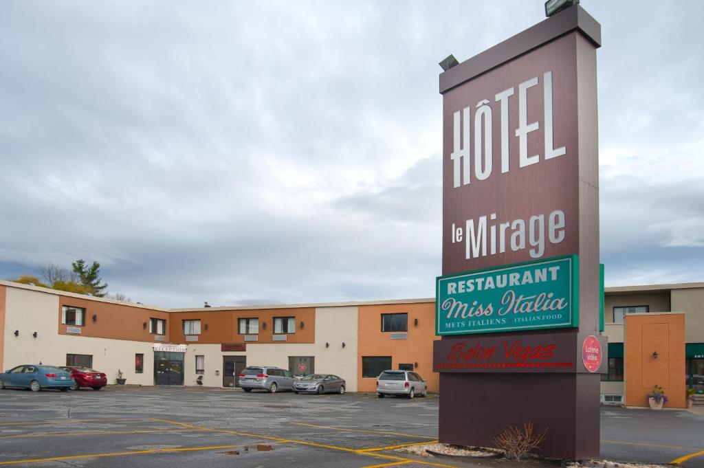 un panneau indiquant un hôtel dans un parking dans l'établissement Hotel Le Mirage, à Saint-Basile-le-Grand