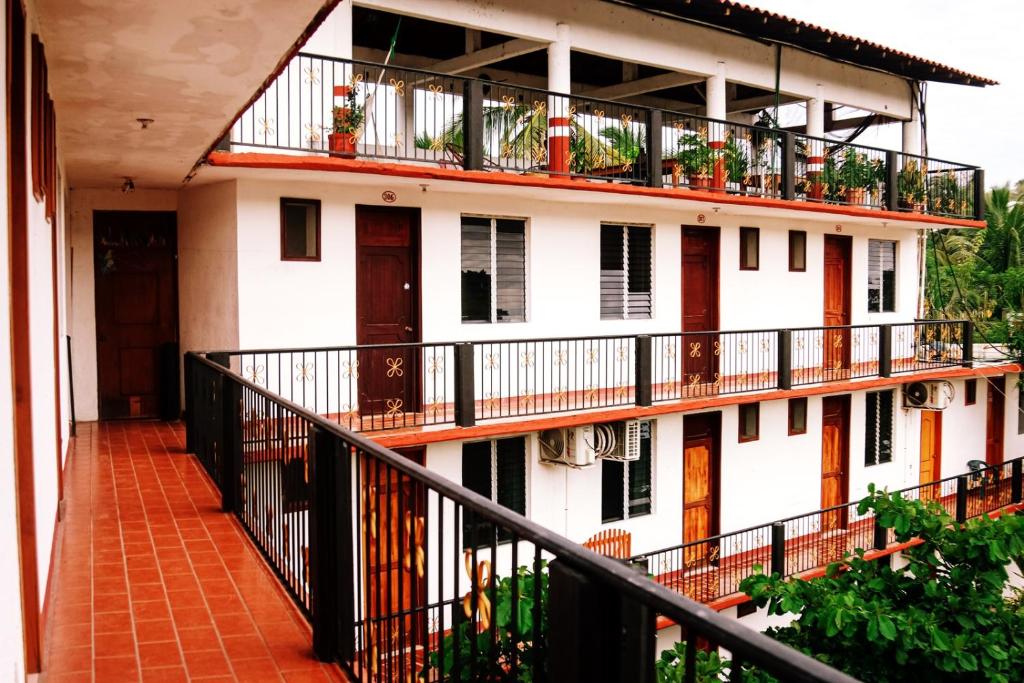 a white building with balconies and plants on it at Hotel Yurimar in Puerto Escondido