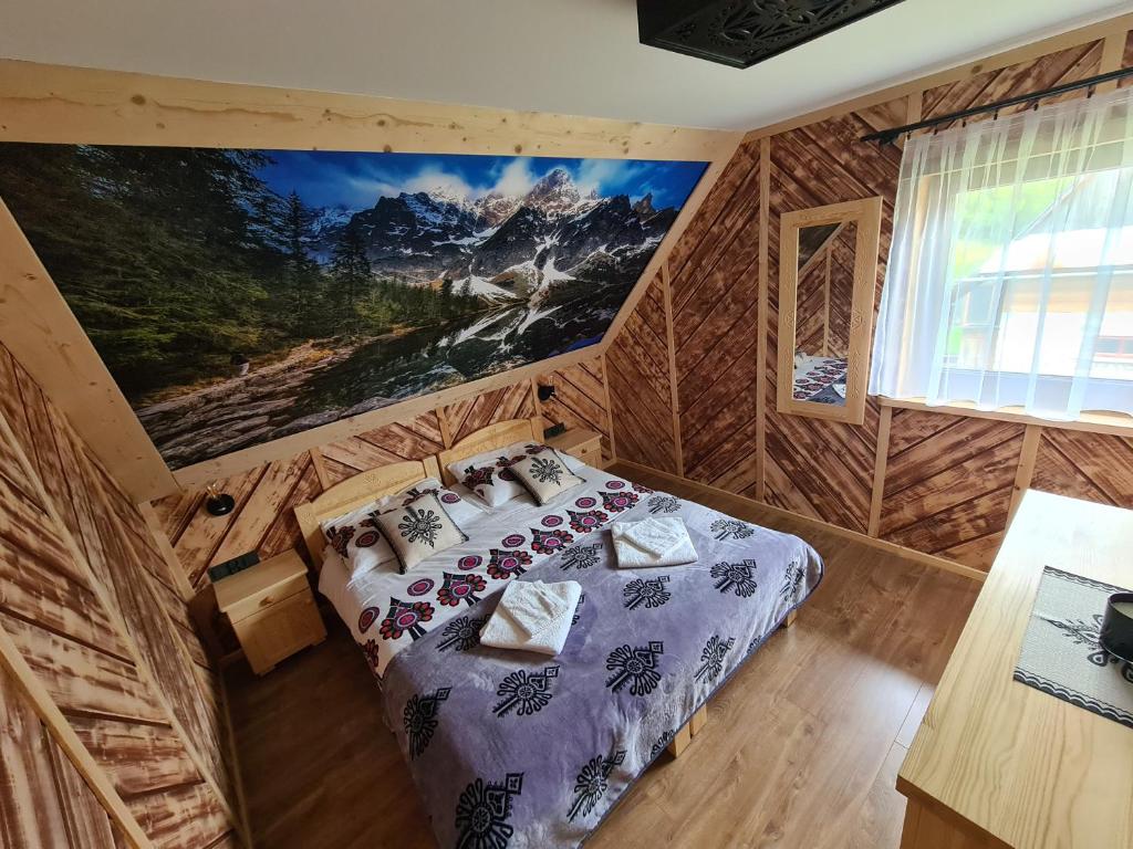 Un dormitorio con una cama en una cabaña de troncos en Domek u Jarząbków, en Ciche