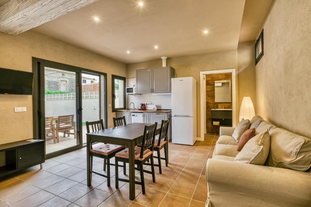 uma cozinha e sala de estar com um sofá e uma mesa em Els Templers em Castelló d'Empúries