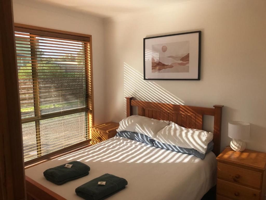 1 dormitorio con 1 cama con 2 toallas en Seahorse Coastal Villas, en Peterborough