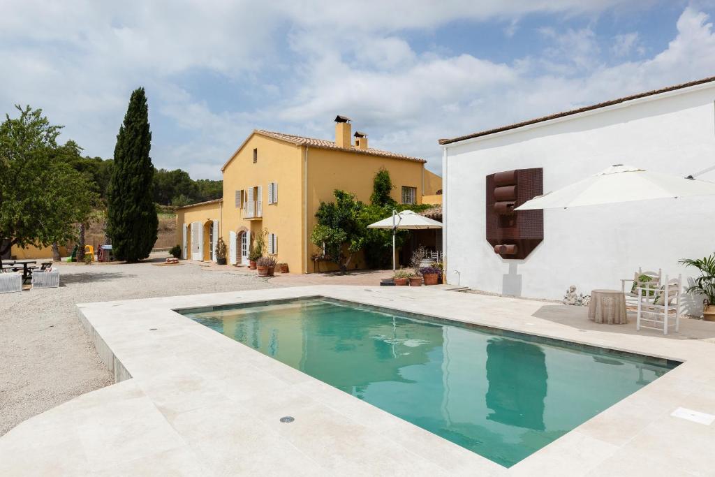 a swimming pool in front of a house at Lidia Rural House in San Martín Sarroca