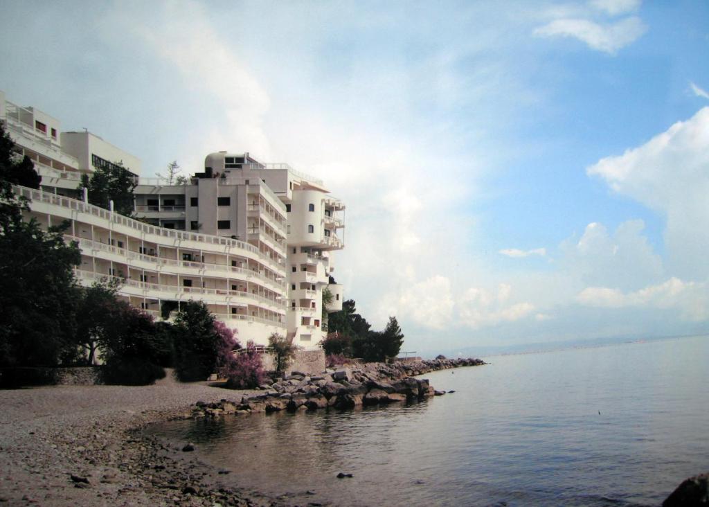 ein großes Gebäude an einem Strand neben dem Wasser in der Unterkunft Residence Dream House in Sistiana