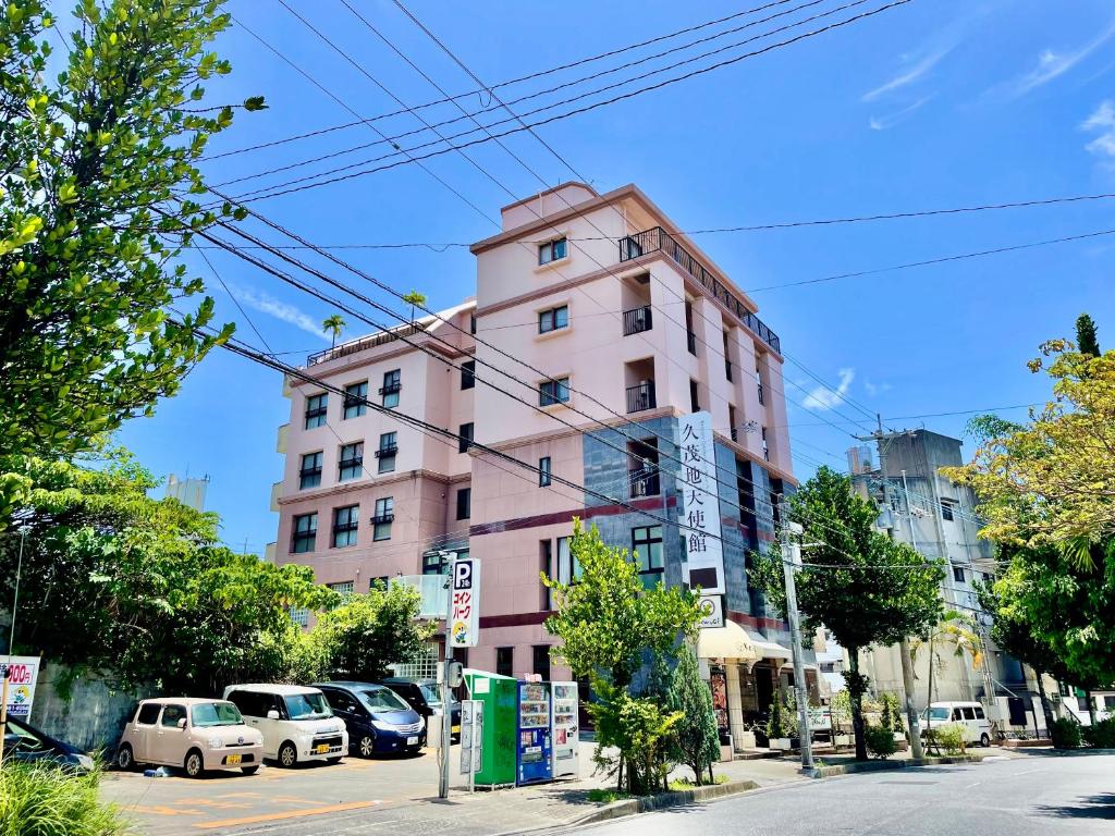 een roze gebouw aan de kant van een straat bij ホテル天使館 久茂地 -Tenshi-Kan- in Naha