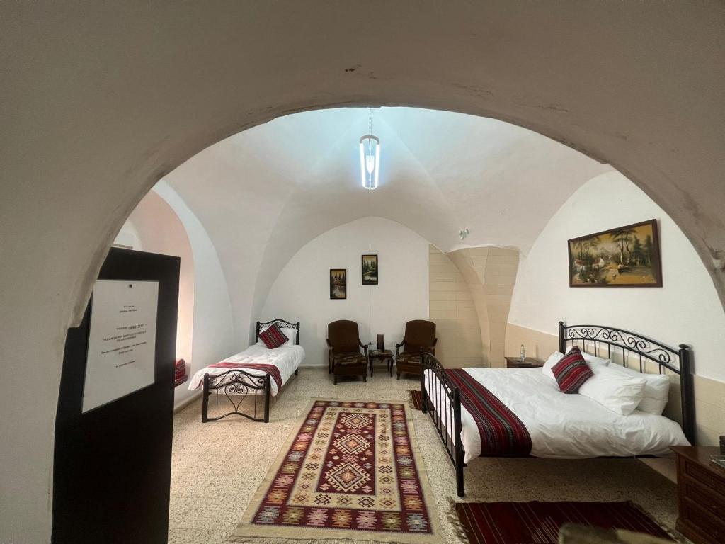 a bedroom with a bed and a table and chairs at Qandeel - Dar Botto in Bethlehem
