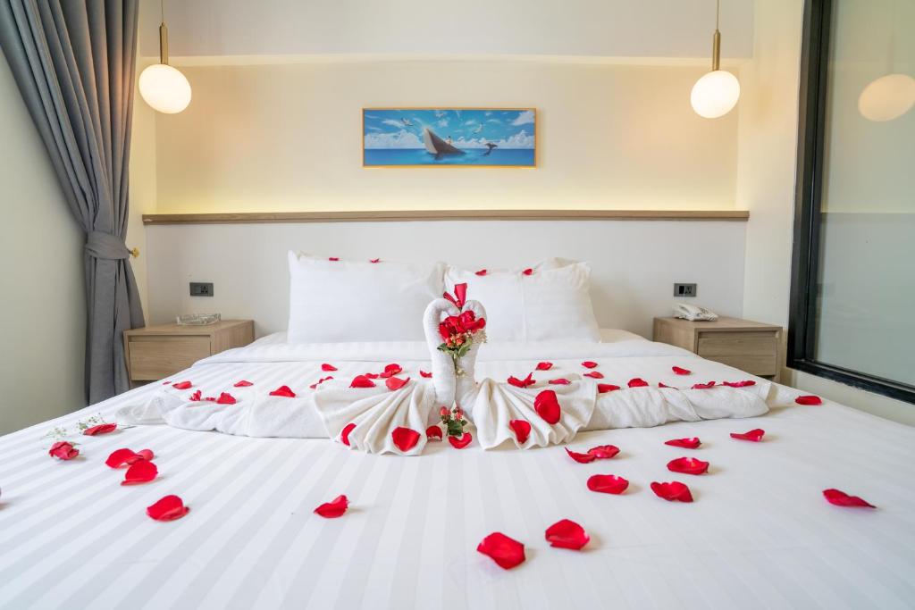 a bed with red roses laying on it at Hak Heng Hotel in Krong Poi Pet