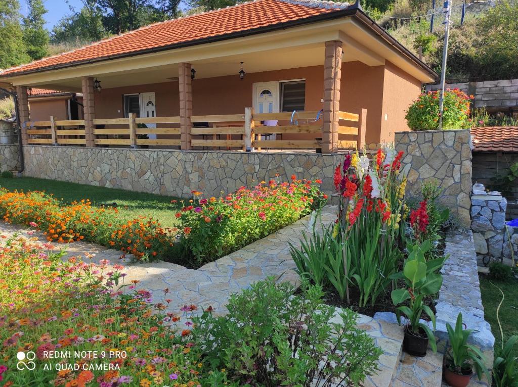 ein Haus mit einem Garten mit Blumen davor in der Unterkunft Vila Vera Borsko Jezero in Bor