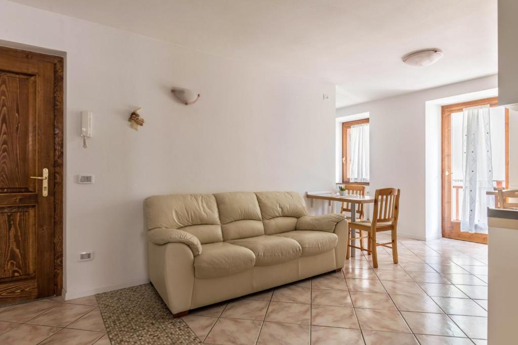 sala de estar con sofá y mesa en Appartamento Lucia, en Baselga di Pinè