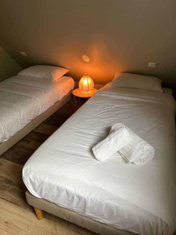 a room with two beds with a towel on the bed at Le Domaine des Bois in Blangy-le-Château