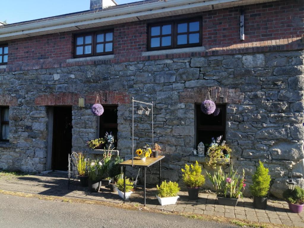 a brick building with plants in front of it at Crover Cottage Twin Room with Lake View in Mountnugent