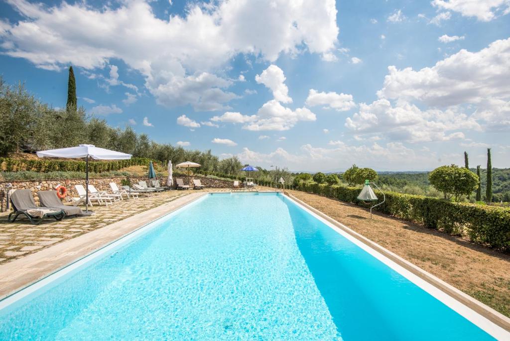 - une piscine dans une villa en provence avec des chaises et des parasols dans l'établissement Casa indipendente nel Chianti, à Castelnuovo Berardenga