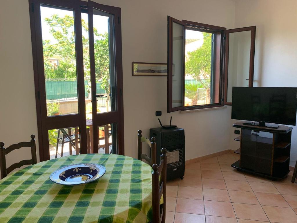 uma sala de estar com uma mesa e uma televisão em A Casa di Nonna em Bosa