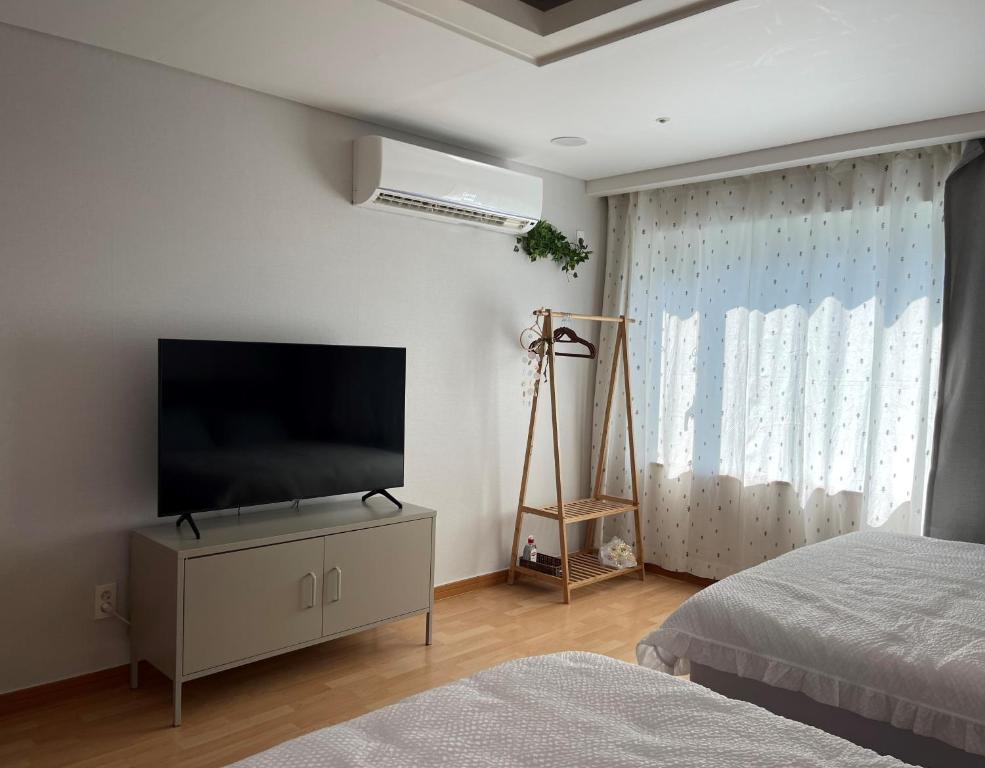 a bedroom with a flat screen tv and a bed at Hongdae Residence 3 - 1min from Hongik Uni station Exit #1 in Seoul