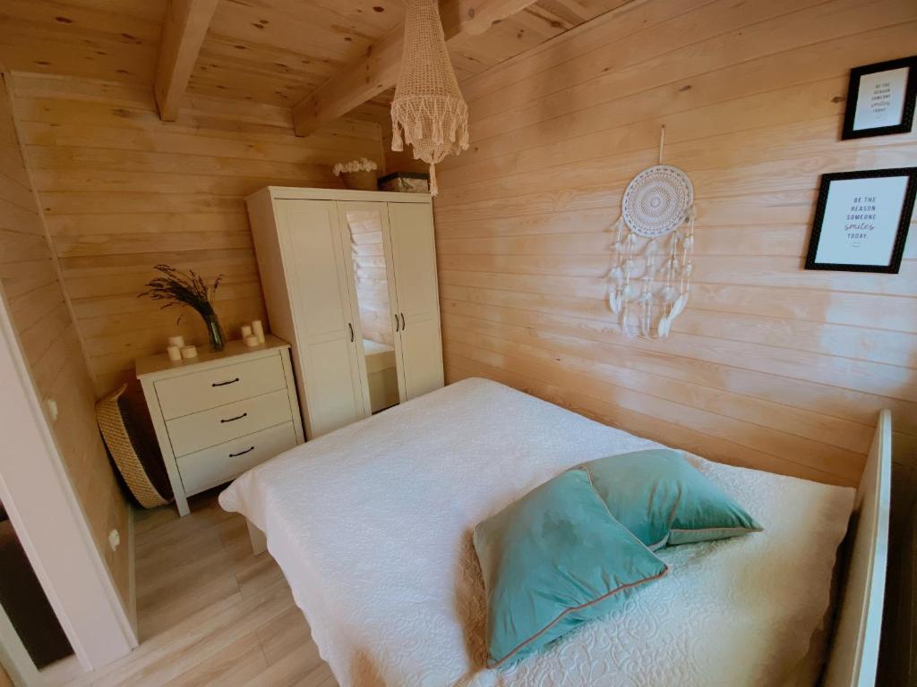 a bedroom with a bed and a wooden wall at Wiejskie Swawole-domki w lesie na wsi 