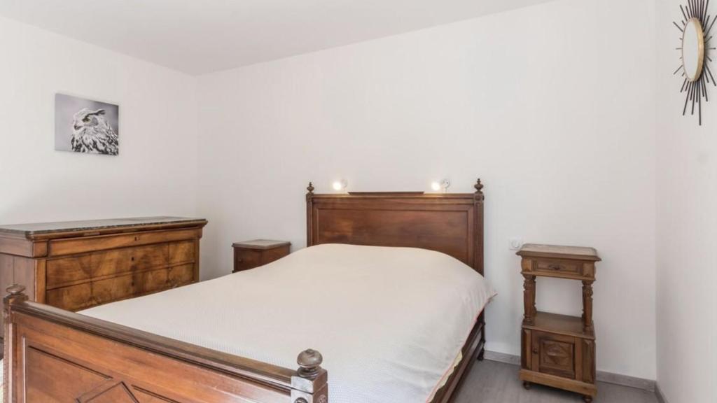 ein Schlafzimmer mit einem Holzbett und zwei Nachttischen in der Unterkunft Métris 2/3 in Corre